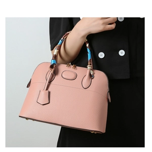 Pink lychee grain leather handbag with silk scarf handle detail and gold hardware