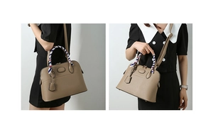 Detail of khaki leather Boston bag with litchi texture and striped handle scarf