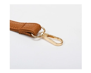 Detail of detachable brown leather shoulder strap with golden swivel hook and pebble texture