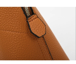 Close-up of metal zipper and lychee grain leather texture on brown shoulder bag