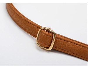 Detail of brown litchi pattern leather strap with adjustable gold square metal buckle