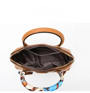 Internal view of brown leather tote showing spacious compartments and zipper pockets