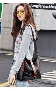 Gros plan sur le sac en cuir PU noir avec rayures contrastées rouges et détails de clous