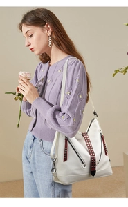 Détail du grand sac cabas blanc avec zips en V et bande en cuir marron à rivets