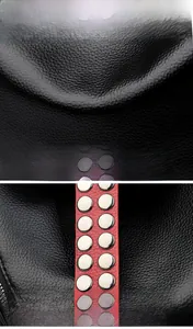 Détail du sac en cuir noir avec bandoulières rouges et rivets métalliques argentés