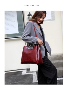 Detail of red embossed crocodile tote bag with snakeskin handle and gold hardware