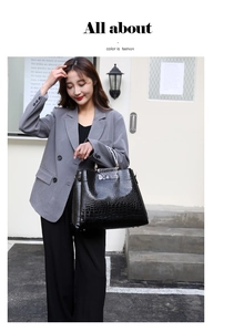 Close-up of black embossed leather handbag with stylish snakeskin pattern contrast details