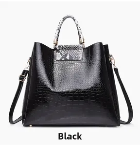 Close-up of black crocodile pattern tote with snake print handles and gold hardware