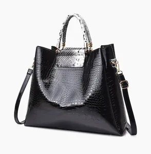 Side view of black glossy crocodile embossed tote with snakeskin texture handles