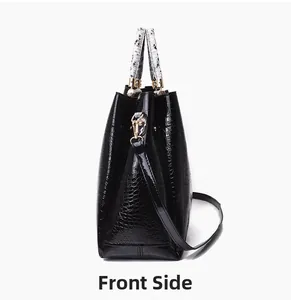 Detail of black croc-embossed handbag with contrasting snake print handle and gold rings