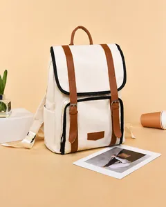 Close-up of contrast color canvas backpack with brown faux leather straps and trim