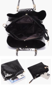 Detail of black crocodile embossed tote bag interior and matching envelope clutch