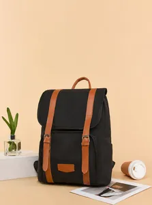 Detail of a vintage canvas backpack with brown faux leather trim and dual buckle flap cover