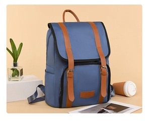 Detail of navy blue nylon backpack with brown faux leather buckle straps on stone decor