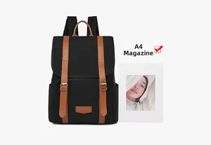 Detail shot of black canvas backpack showing A4 magazine size comparison and leather straps