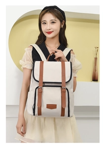 Asian model wearing a beige nylon backpack with brown leather straps and metal buckles