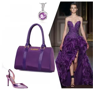 Detailed view of a purple nylon handbag with leather handles and gold metal hardware