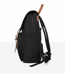 Side view of black nylon backpack with brown leather accents and multi-zipper compartments