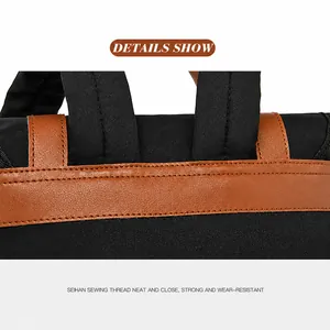Close-up of reinforced stitching and brown leather handle on a black nylon backpack