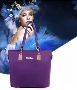 Detail of purple waterproof nylon tote with golden logo and chain handle decoration