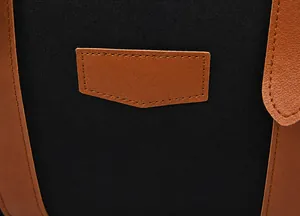 Detail of black nylon fabric with brown PU leather trim and reinforced stitching