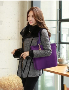 Detail of dark purple nylon tote bag with golden chain accents and smooth satin finish