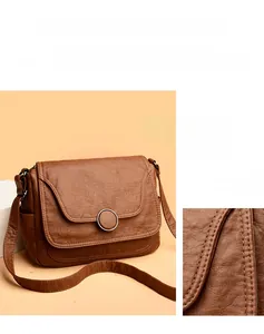 Detailed close-up of textured litchi grain leather and stitching on brown shoulder bag