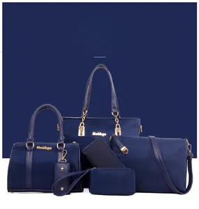 Detailed close-up of 5-piece navy blue nylon handbag set with golden hardware details