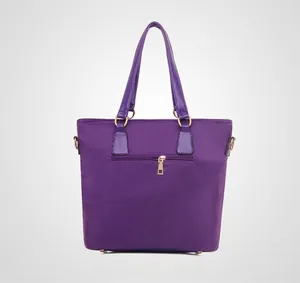 Detail of the purple nylon tote bag featuring a back zipper pocket and gold hardware