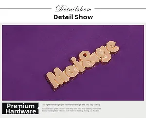 Detailed macro of the gold zinc alloy hardware logo on the purple leather handbag texture