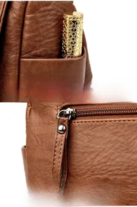 Close-up of brown textured leather bag featuring side pocket and long metal zipper detail