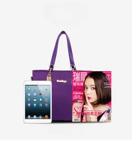 Purple nylon tote bag with gold chain shown alongside a tablet for size comparison