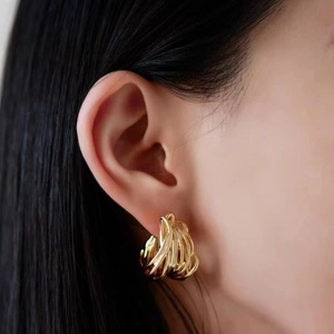 Luxe layered gold-plated C-shaped twisted metal hoop earrings shown on model