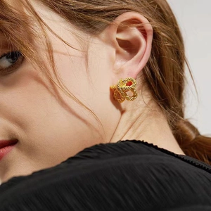 Gros plan d'une boucle d'oreille nœud doré avec texture tressée portée par un mannequin