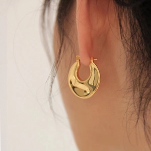 Minimalist chunky gold hoop earrings with polished water ripple texture for women