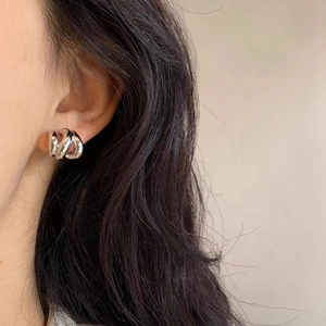Orecchini a cerchio ritorti geometrici in argento S925 su una modella donna