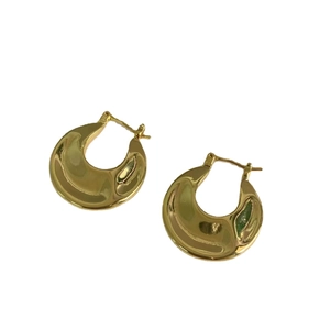 Polished gold textured chunky hoop earrings featuring a minimalist wavy surface design