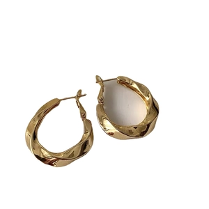 Polished gold twisted geometric hoop earrings with an irregular oval shape design