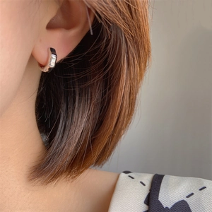 Minimalist bamboo-style silver hoop earrings shown on model for a modern commute look
