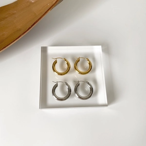 Dettaglio di orecchini a cerchio ritorti placcati oro 18 carats e argento su base