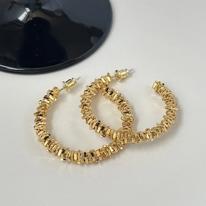 Boucles d'oreilles créoles dorées en C avec finition texturée scintillante au style minimaliste
