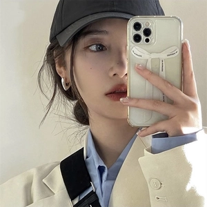 Detailed view of model wearing silver heart earrings and holding chic ribbon phone case
