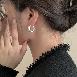 Silver round earrings with hammer-textured finish worn on model for stylish look