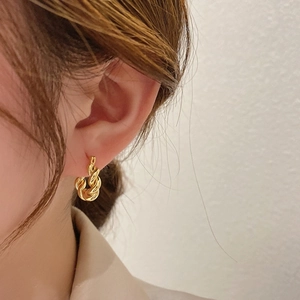 Créoles torsadées plaquées or 18 carats de style français portées par un mannequin