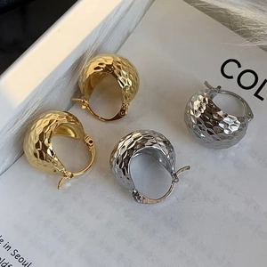 Boucles d'oreilles dôme en or et argent avec finition martelée sur fond blanc