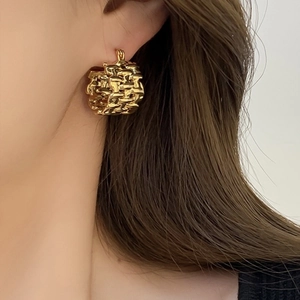 Irregular gold woven ball earrings featuring a textured metallic glossy finish