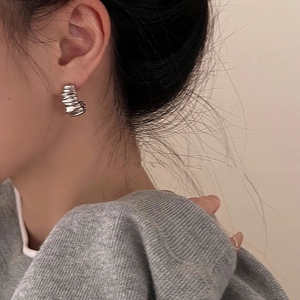 Close-up of irregular textured S925 silver C-shape hoop earrings on model ear