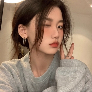 Minimalist silver geometric hoop earrings and ring set on model with casual style