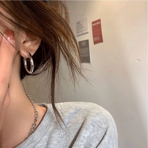 Minimalist silver hoop earrings and delicate chain necklace on model for a sleek style