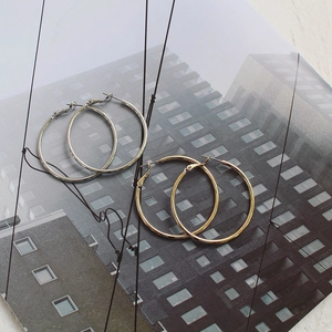 Detailed view of silver and gold thin hoop earrings with a polished mirror finish